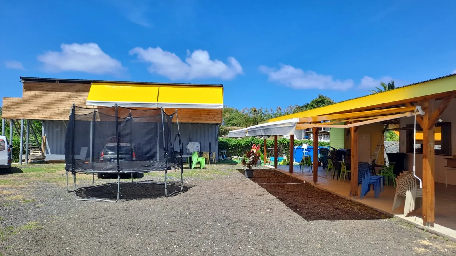 Stores monobloc à toile jaune au-dessus des terrasses d'un restaurant