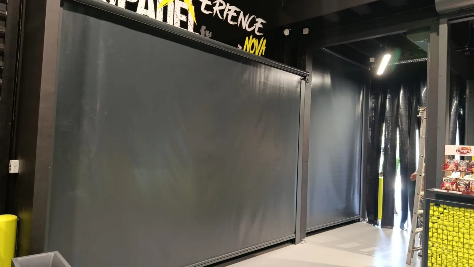 Stores verticaux à coulisses en toile occultante dans un complexe de padel