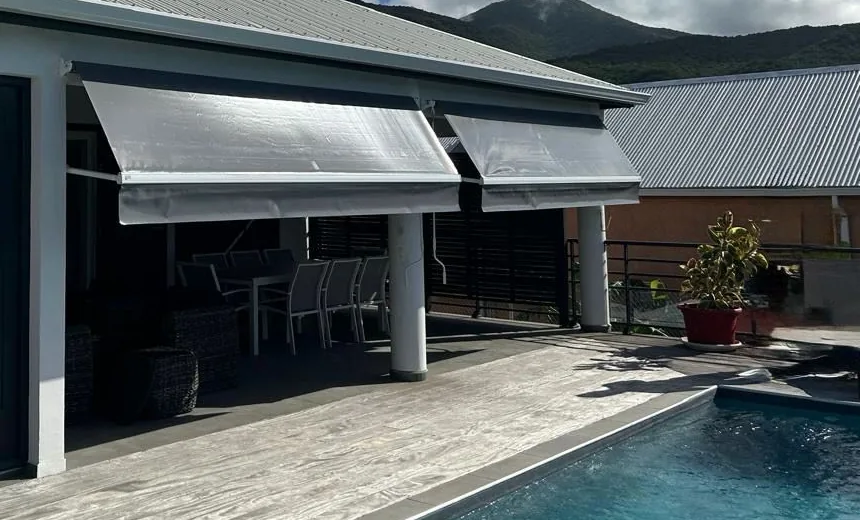 Stores bras droits gris installés au-dessus d'une terrasse de villa avec piscine